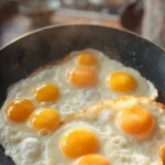 Vaječná jídla na pánvi s několika vajíčky připravenými různými způsoby.