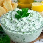 Krémová bylinková omáčka tzatziki na talíři s bylinkami