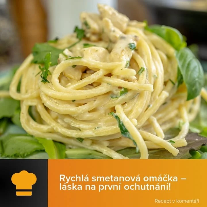 Těstoviny se smetanovou omáčkou na talíři s čerstvými bylinkami